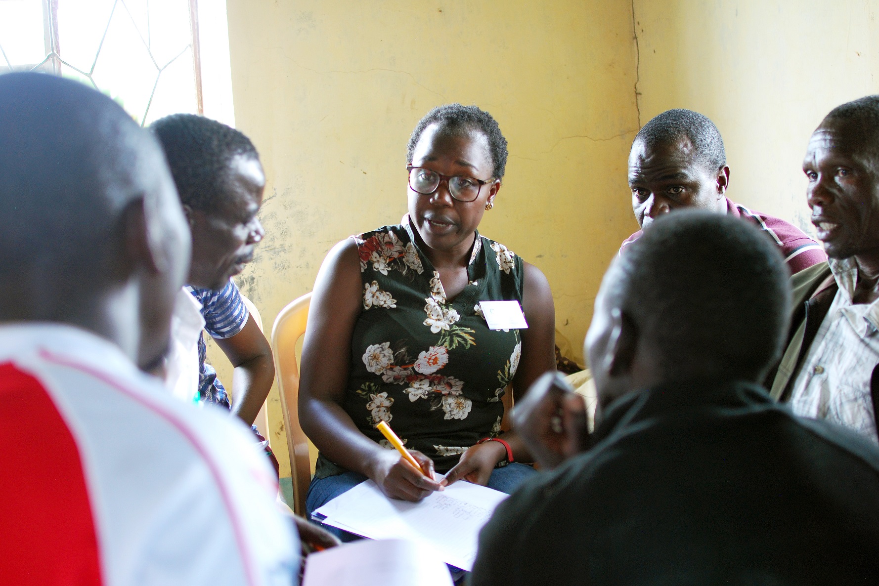 Abigail, an IDinsight surveyor, conducts a participatory wealth ranking exercise with community leaders in Nyatika, Migori, Kenya to identify community members for the survey